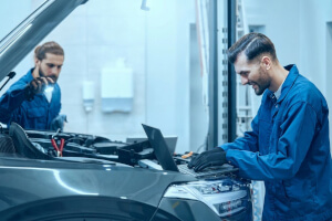 Zwei Mechaniker führen Servicearbeiten an einem Land Rover durch.