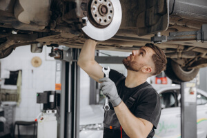 Fachmann überprüft die Bremse in einer Werkstatt.