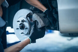 Mechaniker kontrolliert die Bremsen fachgerecht in der Werkstatt