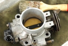 Eine ausgebaute Drosselklappe bei der Reinigung und Reparatur