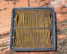 Ein verschmutzter Innenraumfilter auf metallener Oberfläche
