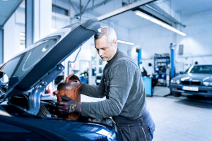 Mechaniker füllt Kühlflüssigkeit in der Werkstatt nach