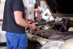 Mechaniker bei der Messung eines Peugeots während der Inspektion