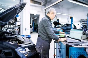 Fachmann beim Zahnriemenwechsel an einem Opel